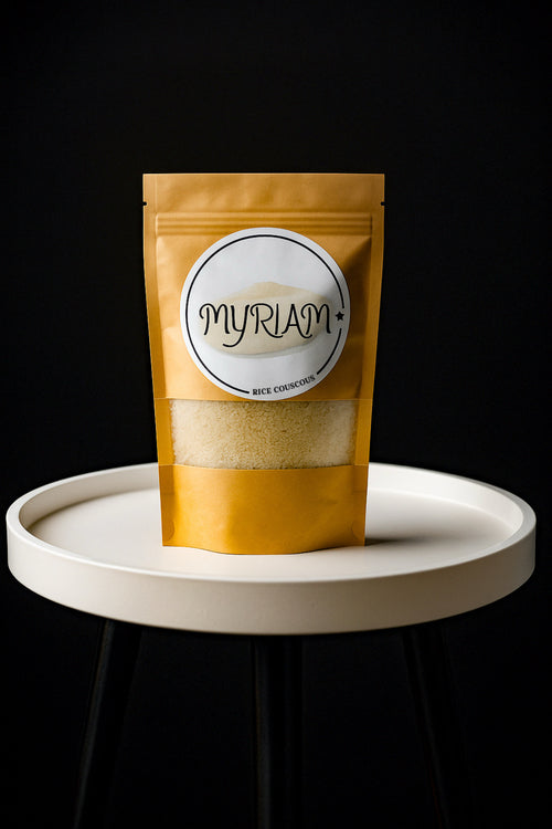 Myriam Rice Couscous in a gold pouch with a clear window on a white display table.